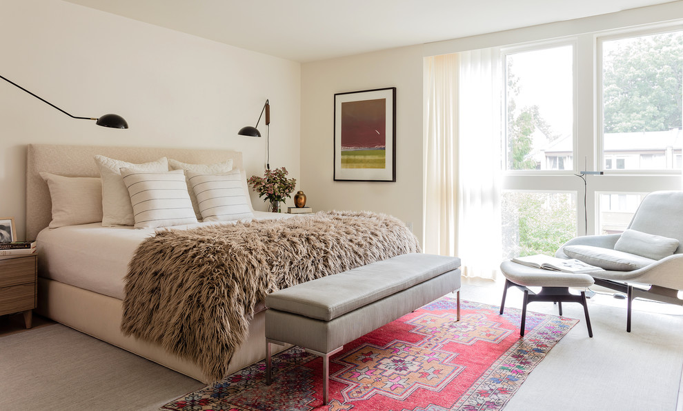 Immagine di una camera matrimoniale minimal con pareti beige e parquet chiaro