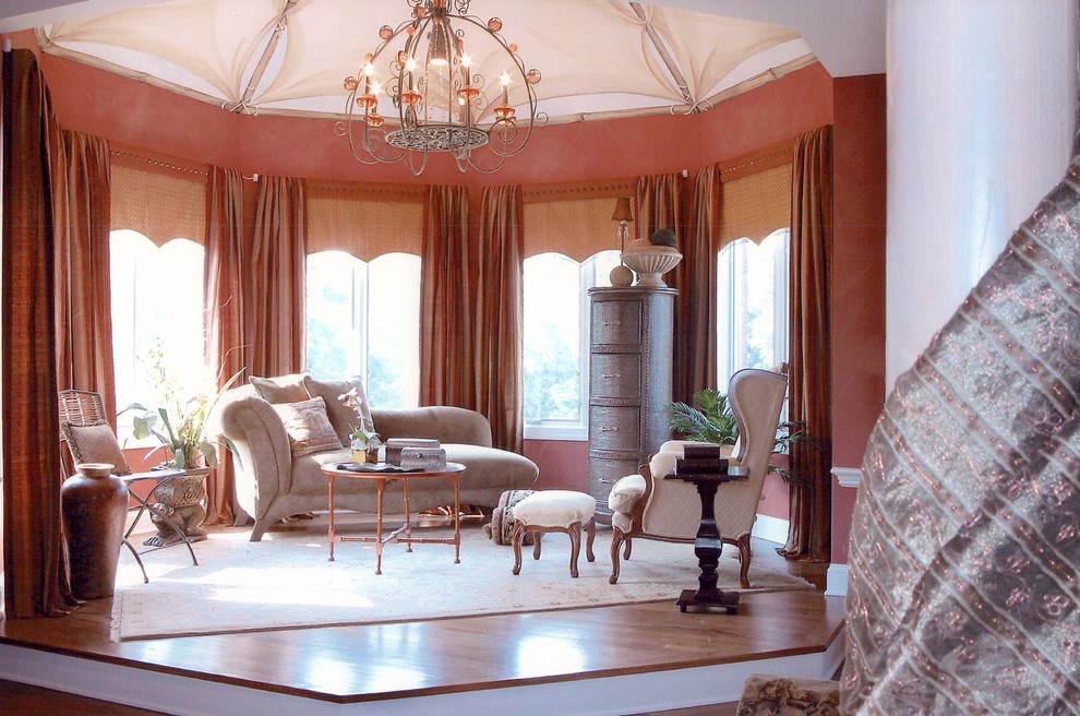Diseño de dormitorio principal clásico grande sin chimenea con paredes rojas, suelo de madera en tonos medios y suelo marrón