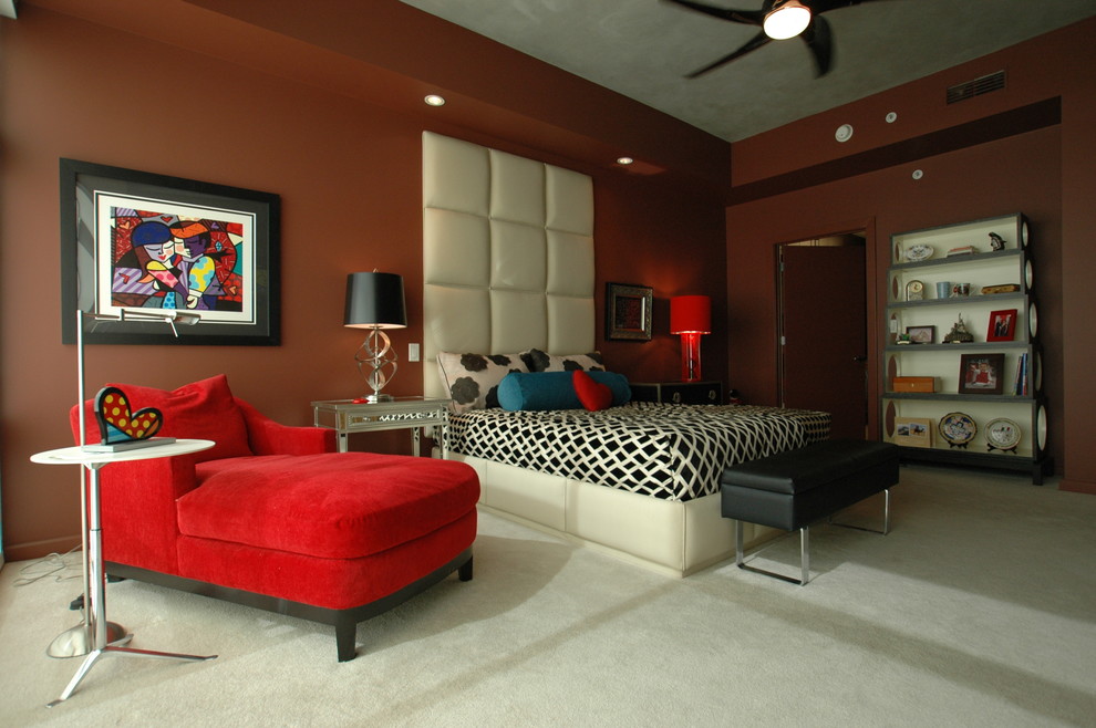 Immagine di una grande camera matrimoniale design con pareti arancioni e moquette