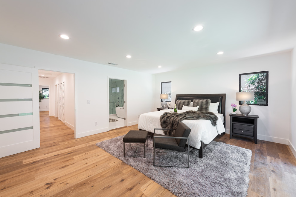 Inspiration for a mid-sized contemporary master medium tone wood floor and brown floor bedroom remodel in Los Angeles with white walls and no fireplace