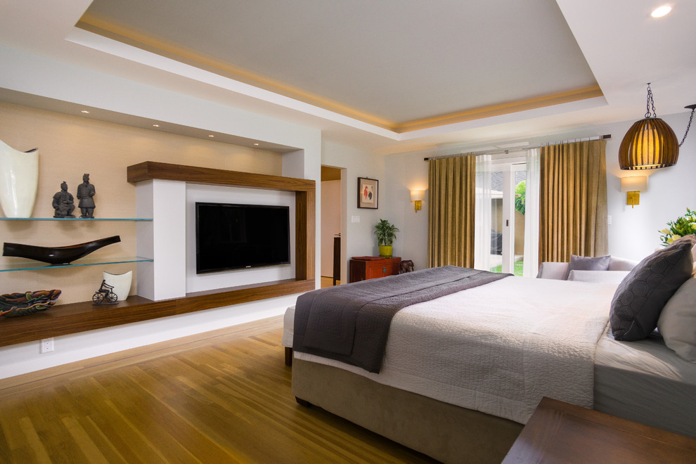 Imagen de dormitorio principal retro de tamaño medio con paredes beige, suelo de madera clara y todas las chimeneas