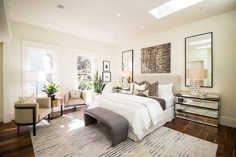 This is an example of a large contemporary master bedroom in San Diego with white walls, dark hardwood flooring and brown floors.