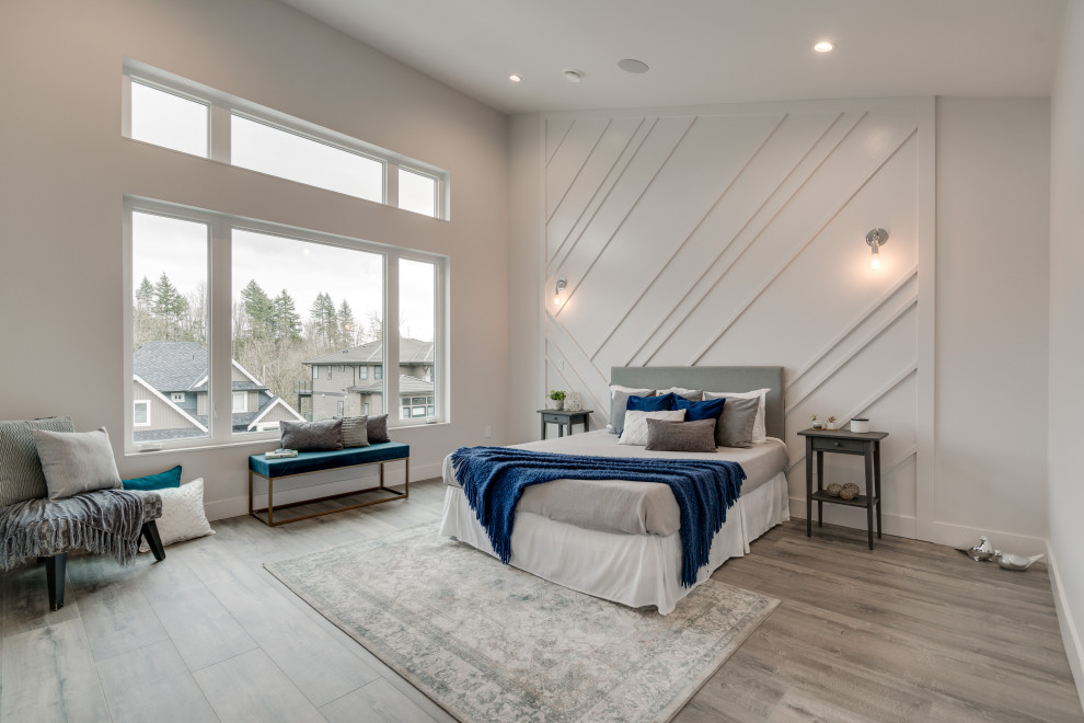Großes Modernes Hauptschlafzimmer mit weißer Wandfarbe, Laminat, grauem Boden, gewölbter Decke und Holzwänden in Vancouver