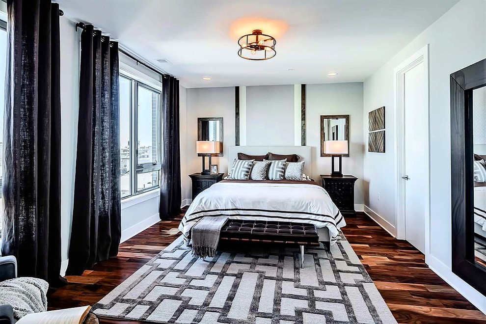 Foto de dormitorio principal contemporáneo grande sin chimenea con paredes grises, suelo de madera en tonos medios y suelo marrón