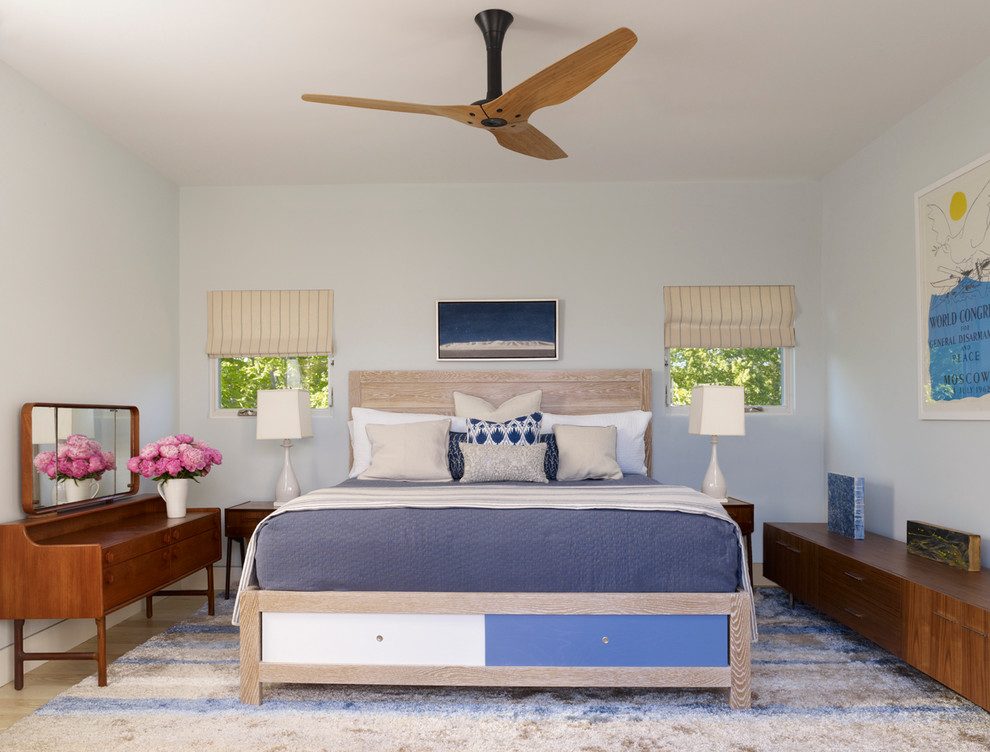 Diseño de dormitorio contemporáneo sin chimenea con paredes azules y suelo de madera clara