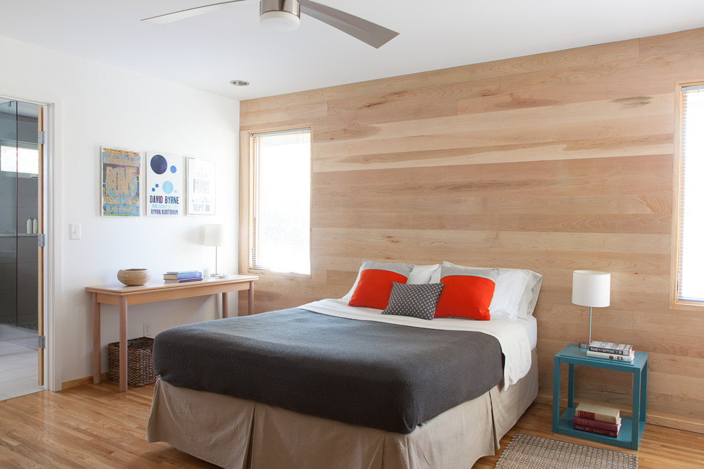 Ejemplo de dormitorio principal minimalista de tamaño medio sin chimenea con paredes blancas y suelo de madera en tonos medios