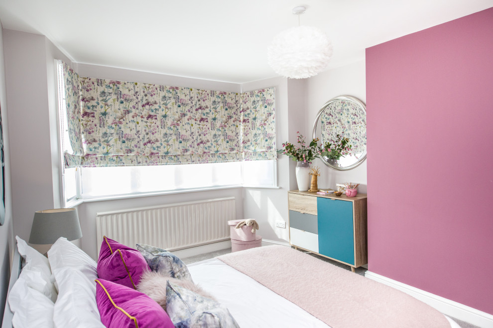 Modern inredning av ett stort sovrum, med rosa väggar, heltäckningsmatta och beiget golv