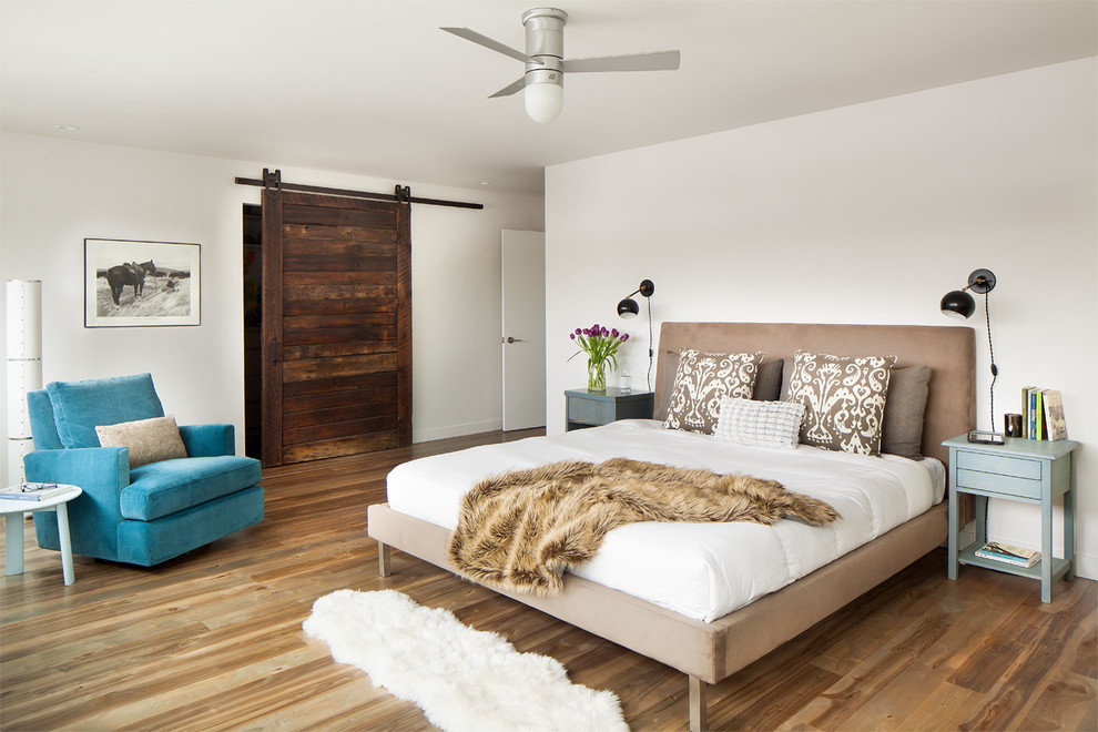Ejemplo de dormitorio principal actual con paredes blancas y suelo de madera en tonos medios
