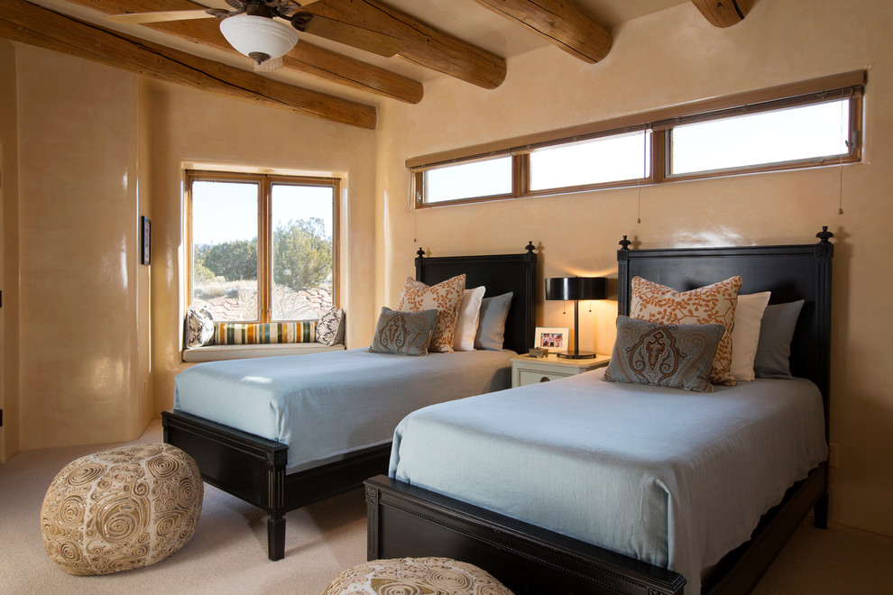 This is an example of a bedroom in Albuquerque with beige walls and carpet.