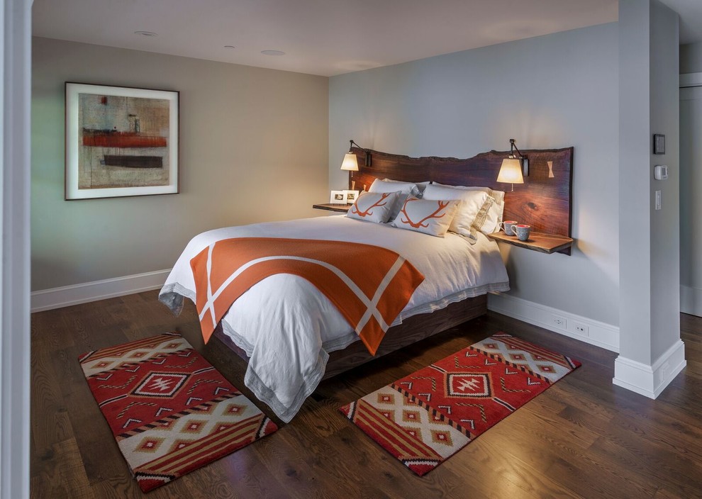Diseño de dormitorio principal rural de tamaño medio sin chimenea con paredes grises, suelo de madera en tonos medios y suelo marrón