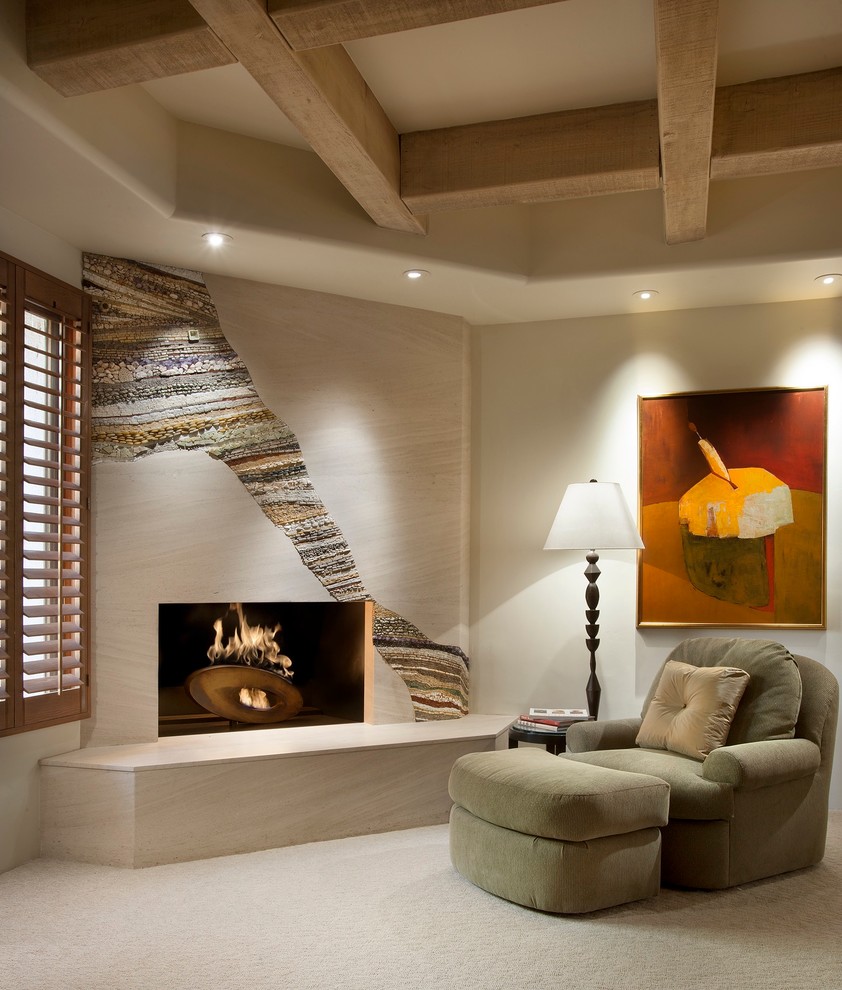Cette image montre une grande chambre design avec un mur beige, une cheminée d'angle et un manteau de cheminée en pierre.