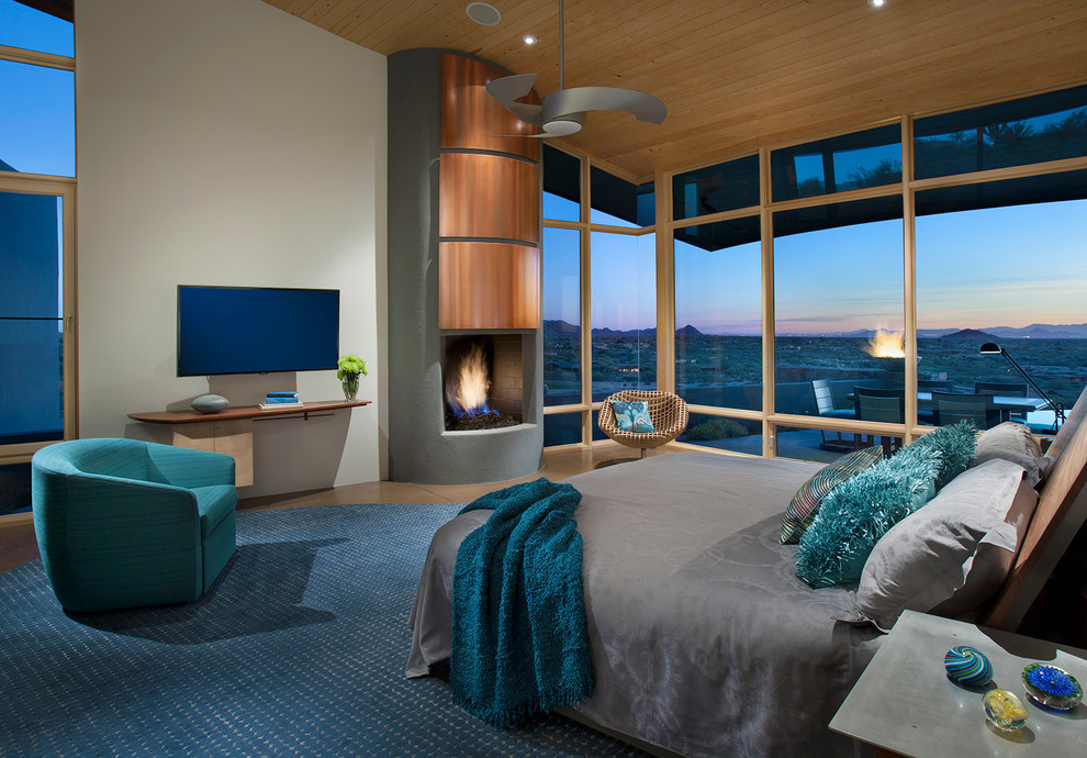 フェニックスにある広いコンテンポラリースタイルのおしゃれな主寝室 (白い壁、コンクリートの床、標準型暖炉、コンクリートの暖炉まわり、ベージュの床) のインテリア