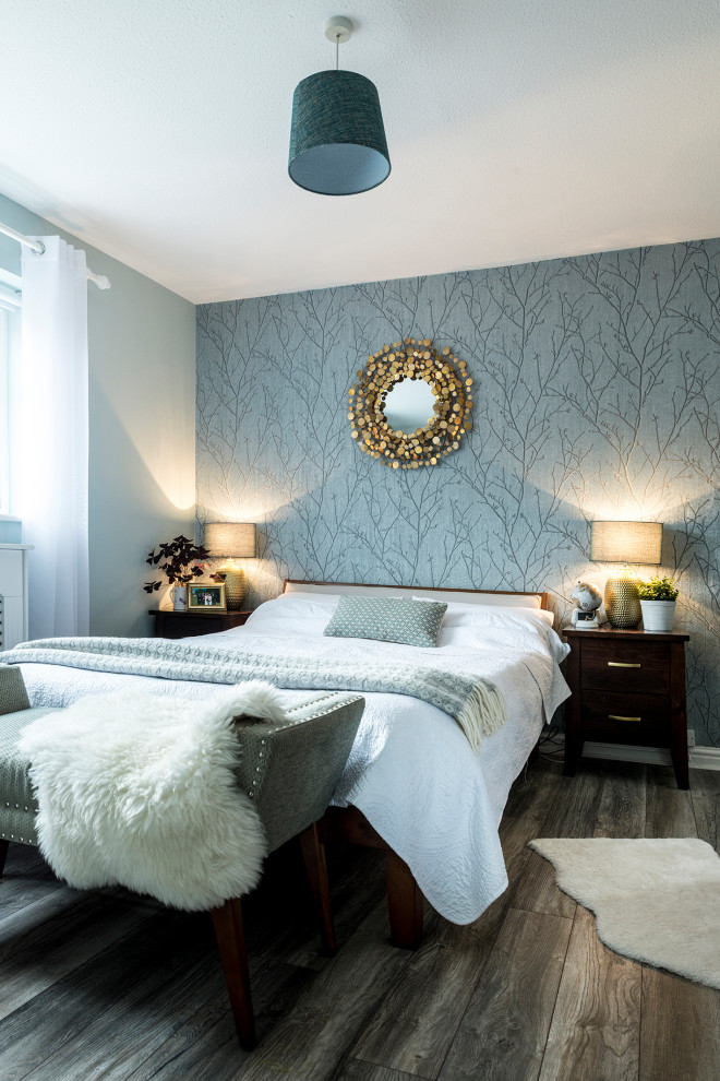 Ejemplo de habitación de invitados actual de tamaño medio con paredes verdes, suelo laminado y papel pintado
