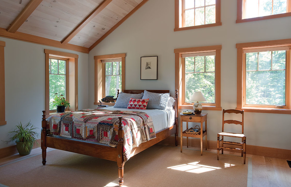 Amerikansk inredning av ett sovrum, med vita väggar, ljust trägolv och beiget golv