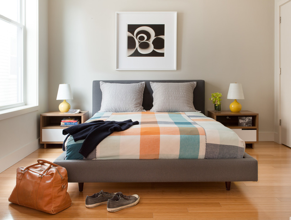 Modelo de dormitorio actual con paredes beige y suelo de madera clara