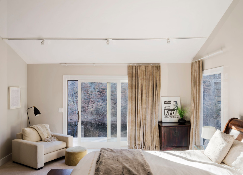 Idee per un'ampia camera matrimoniale minimal con pareti beige e moquette