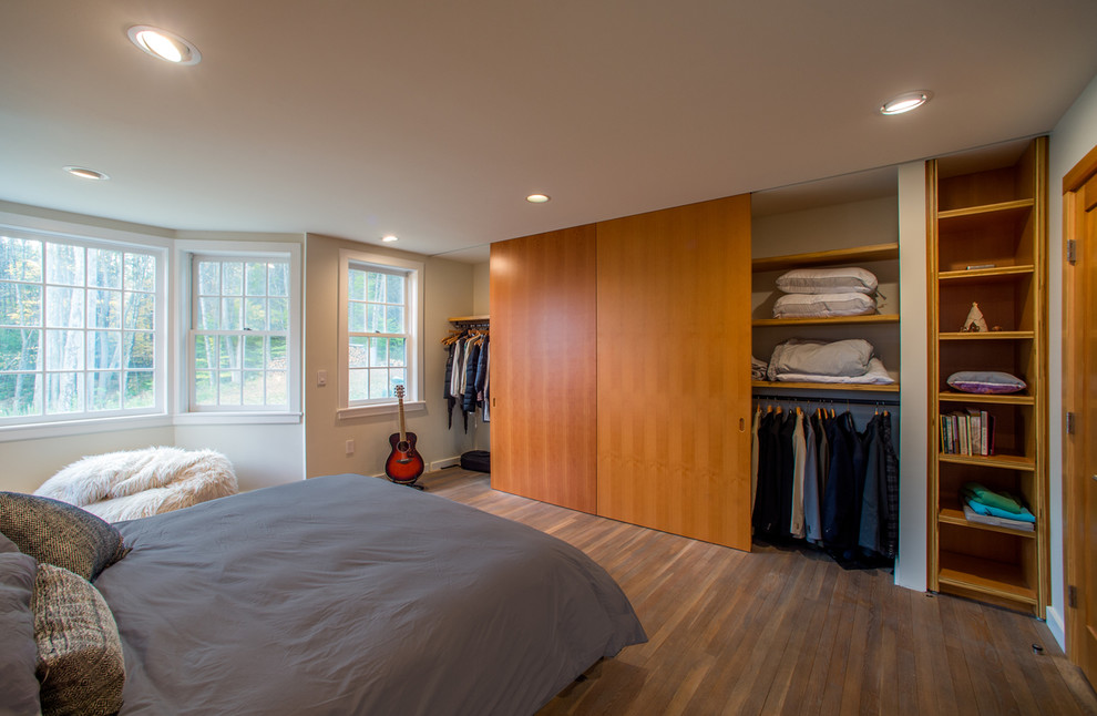 This is an example of a large contemporary master bedroom in Burlington with white walls and medium hardwood flooring.