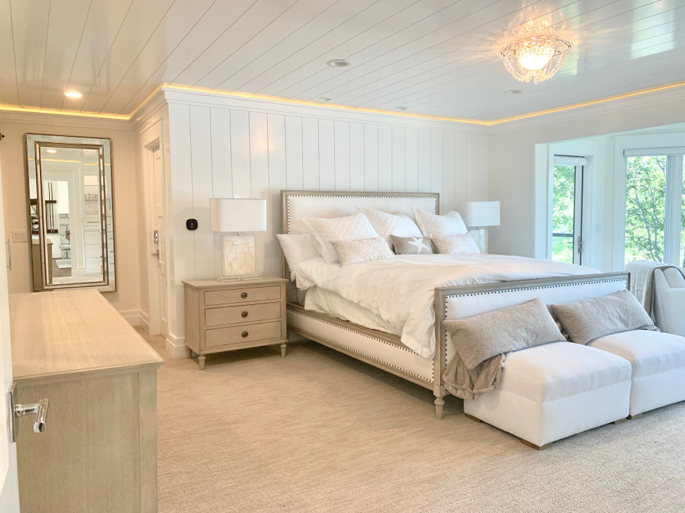 Идея дизайна: большая хозяйская спальня в современном стиле с белыми стенами, ковровым покрытием, стандартным камином, фасадом камина из каменной кладки, бежевым полом и потолком из вагонки