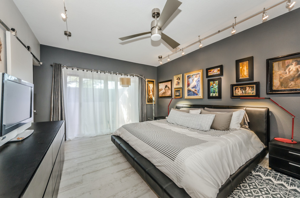 Großes Hauptschlafzimmer ohne Kamin mit grauer Wandfarbe, hellem Holzboden und grauem Boden in Tampa