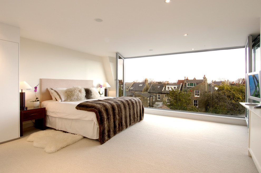 Contemporary bedroom in London with white walls and carpet.