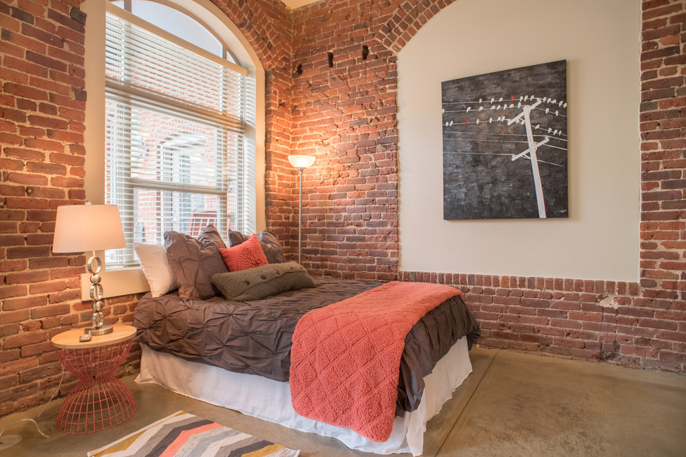 Идея дизайна: спальня в стиле лофт с красными стенами, бетонным полом и акцентной стеной
