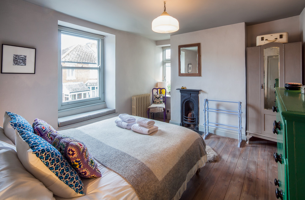 Modernes Schlafzimmer mit blauer Wandfarbe und braunem Holzboden in Devon
