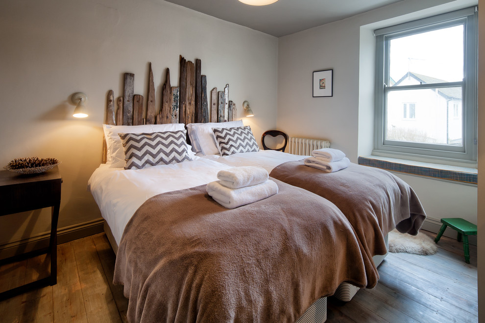 Idee per una camera da letto minimal con pareti blu e pavimento in legno massello medio
