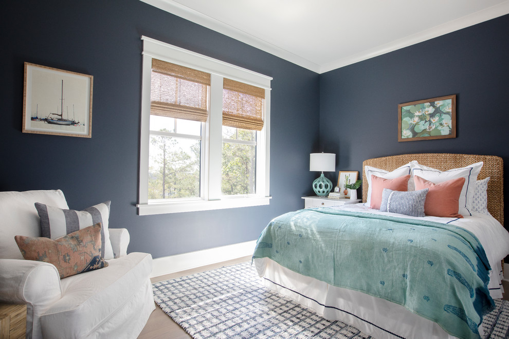 Diseño de dormitorio costero con paredes azules, suelo de madera en tonos medios y suelo marrón