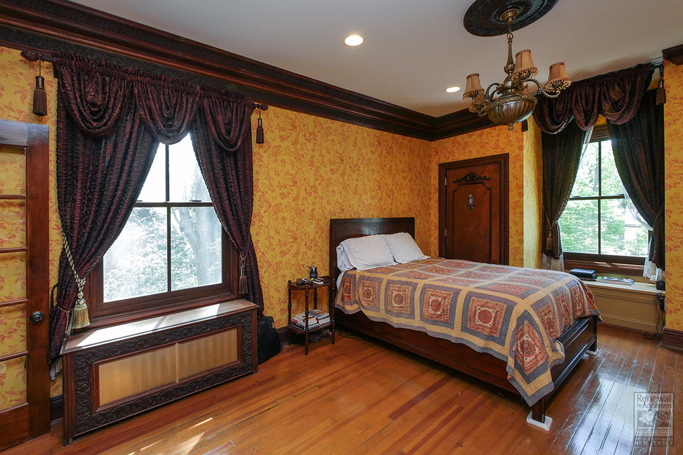 На фото: хозяйская спальня среднего размера с оранжевыми стенами, паркетным полом среднего тона и коричневым полом с