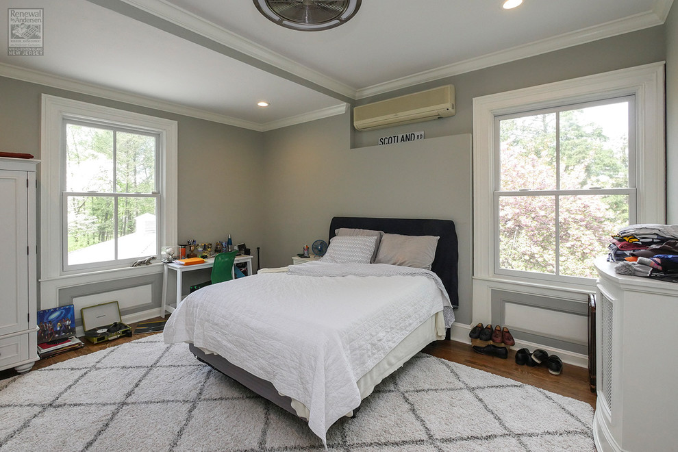 Großes Schlafzimmer ohne Kamin mit grauer Wandfarbe, braunem Holzboden und buntem Boden in Newark