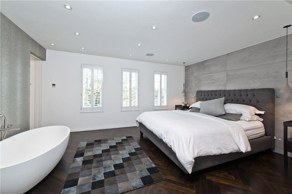 Foto de dormitorio principal contemporáneo de tamaño medio con suelo de madera oscura, suelo marrón y paredes grises