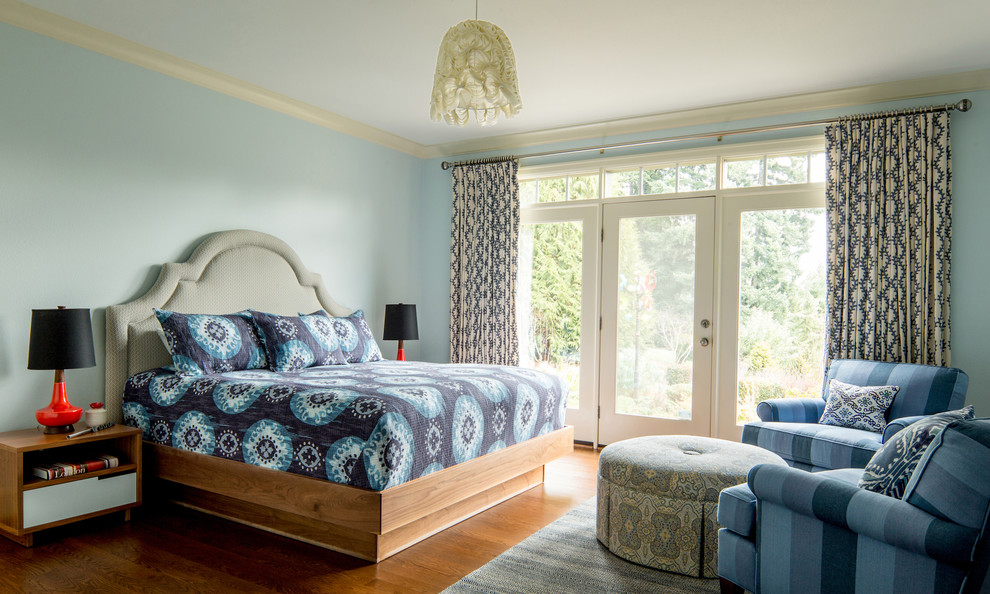 Foto di una camera da letto bohémian con pareti blu e pavimento in legno massello medio