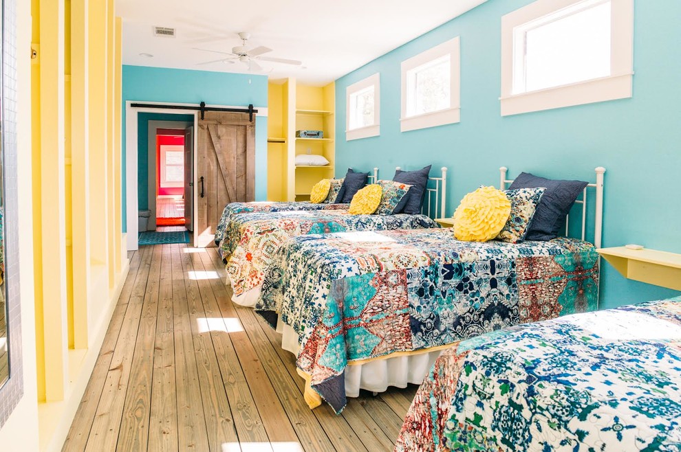 Ejemplo de dormitorio bohemio grande sin chimenea con paredes azules, suelo de madera en tonos medios y suelo marrón