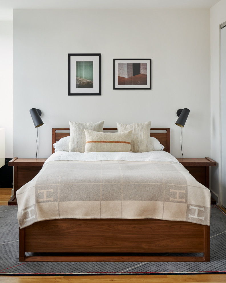 Ejemplo de dormitorio contemporáneo con paredes blancas, suelo de madera en tonos medios y suelo marrón
