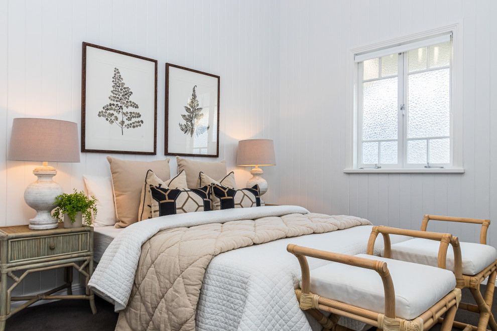 Immagine di una camera da letto costiera con pareti bianche, moquette, pavimento nero e pareti in perlinato