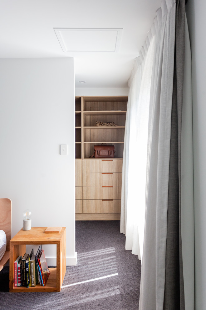 Foto de dormitorio tipo loft urbano de tamaño medio con paredes blancas, moqueta y suelo gris