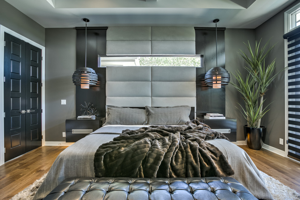 Ejemplo de dormitorio principal actual con paredes grises y suelo de madera clara