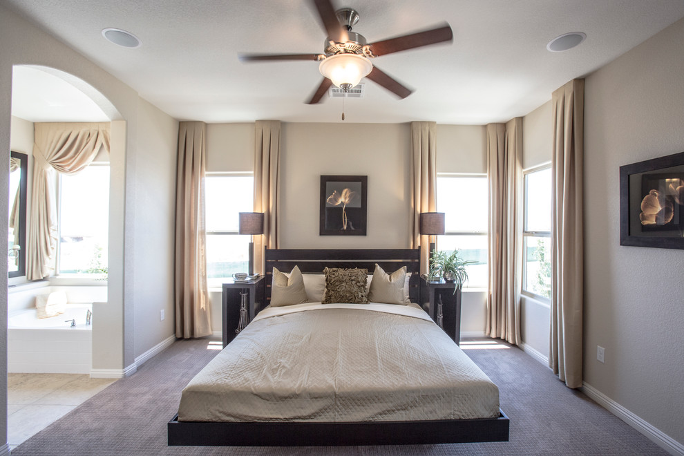 Example of a mid-sized trendy guest carpeted and gray floor bedroom design in Las Vegas with beige walls, no fireplace and a plaster fireplace