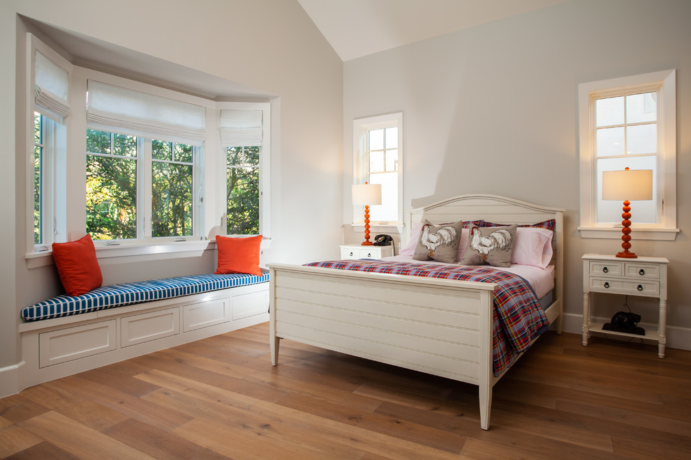 This is an example of a coastal bedroom in Orange County with grey walls, light hardwood flooring and no fireplace.