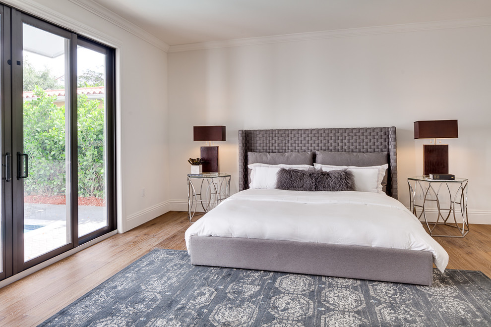 Mittelgroßes Modernes Hauptschlafzimmer ohne Kamin mit beiger Wandfarbe, braunem Holzboden und braunem Boden in Miami