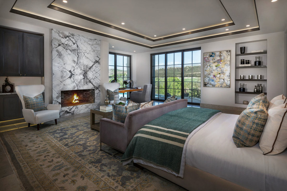 Example of a tuscan bedroom design in Orange County with white walls, a ribbon fireplace and a stone fireplace