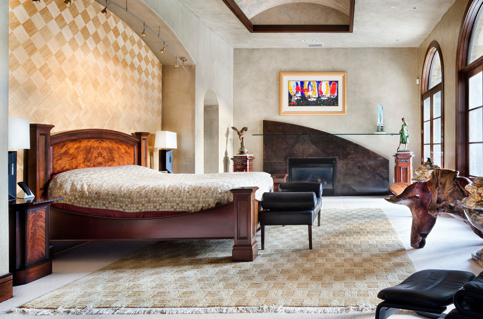 Imagen de dormitorio mediterráneo con paredes beige, todas las chimeneas y marco de chimenea de piedra