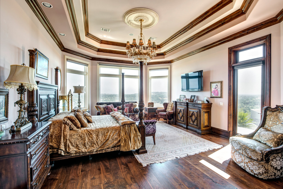 Example of a huge tuscan master dark wood floor and brown floor bedroom design in Austin with beige walls and no fireplace