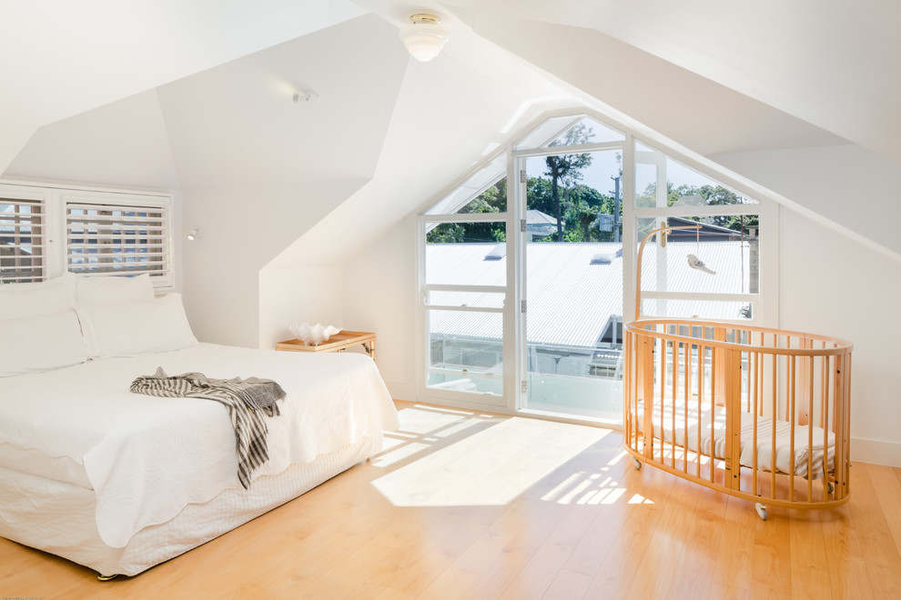 Immagine di una camera da letto design con pareti bianche e parquet chiaro