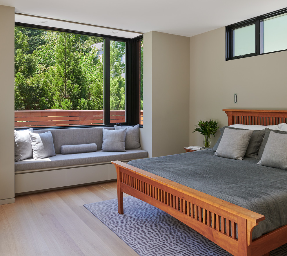 Imagen de dormitorio principal actual de tamaño medio sin chimenea con paredes beige, suelo de madera clara y suelo beige