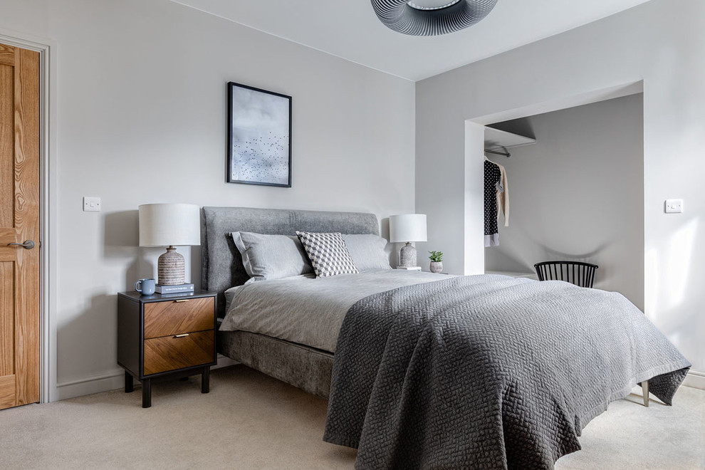 На фото: гостевая спальня среднего размера, (комната для гостей) в стиле неоклассика (современная классика) с серыми стенами, ковровым покрытием и бежевым полом с