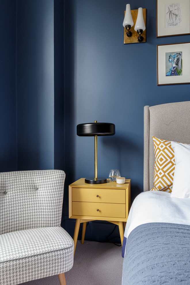 Cette image montre une grande chambre minimaliste avec un mur bleu et un sol gris.
