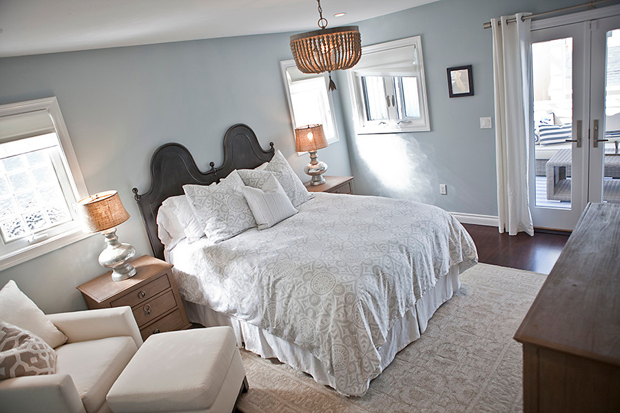 На фото: хозяйская спальня среднего размера в морском стиле с синими стенами и темным паркетным полом без камина с