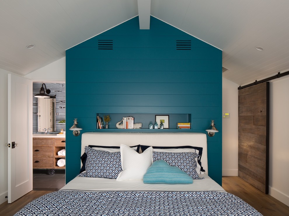 Immagine di una camera da letto stile marinaro con pareti blu e pavimento in legno massello medio