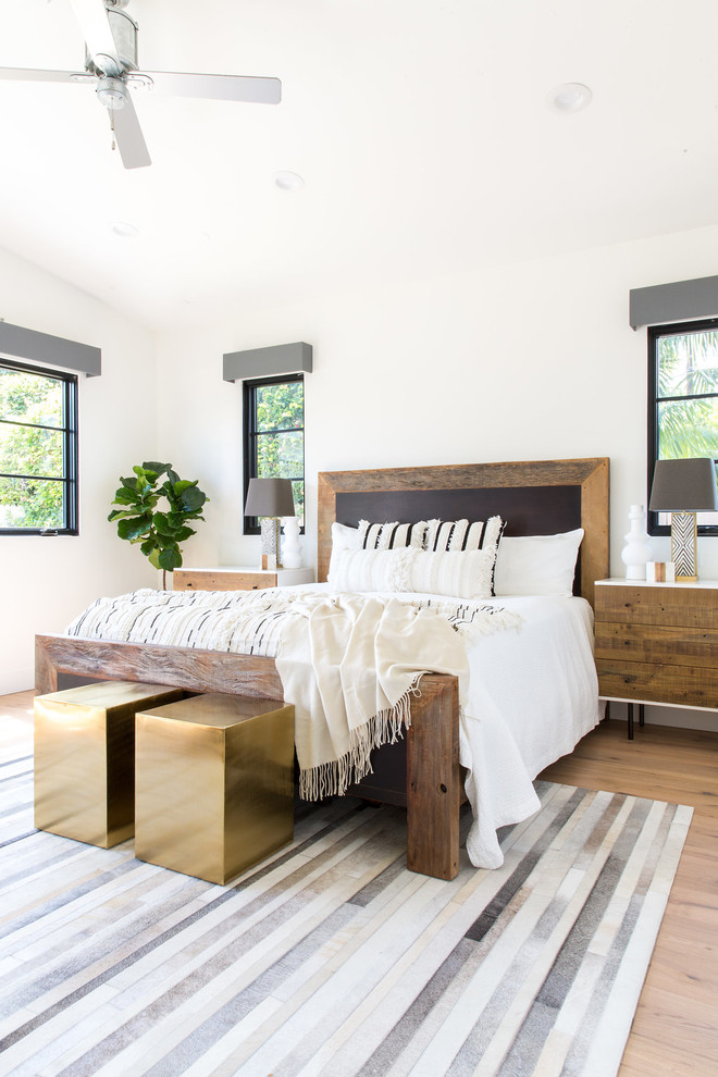 Großes Landhaus Hauptschlafzimmer ohne Kamin mit weißer Wandfarbe und hellem Holzboden in Los Angeles